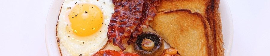 Close up of eggs, bacon, mushrooms, and fried bread.