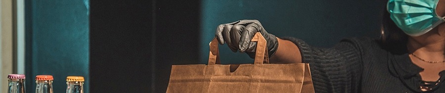 close up of a hand with a take out bag