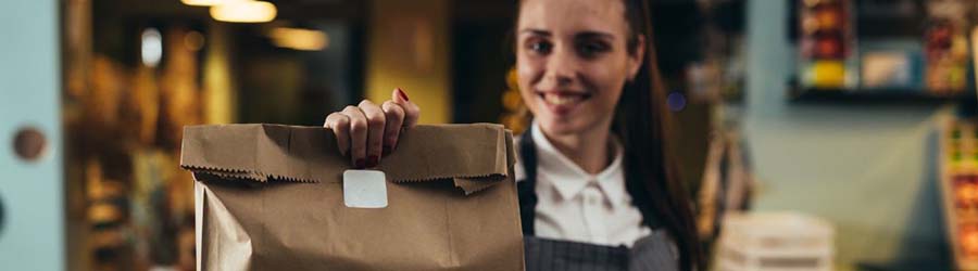 Waitress holding out a bag of food