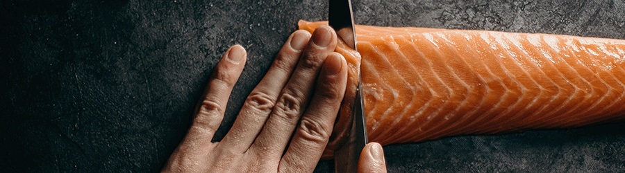 Close up of a chef slicing salmon